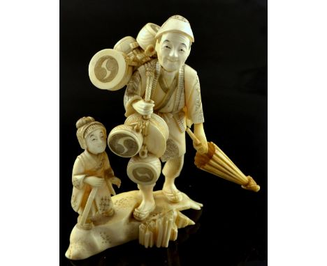 19th century Japanese carved ivory okimono, an itinerant salesman carrying boxes his child standing alongside, signed on base