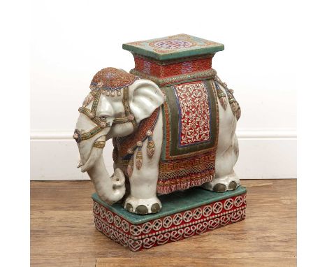 Pottery elephant on standthe elephant cream coloured, with an ornate polychrome saddle and headpiece, with a howdah-style seg
