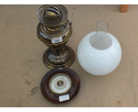 A brass oil lamp plus a circular barometer