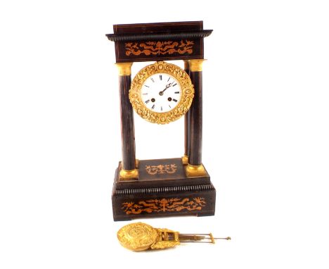 A French Empire style mantel clock in inlaid and gilt mounted ebonised case with four column supports