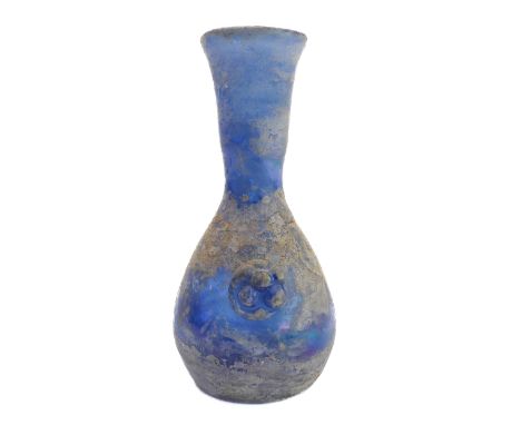 An early style light-blue glass flask of baluster form: waisted neck above two stylised flowerhead appliques opposing, flat c