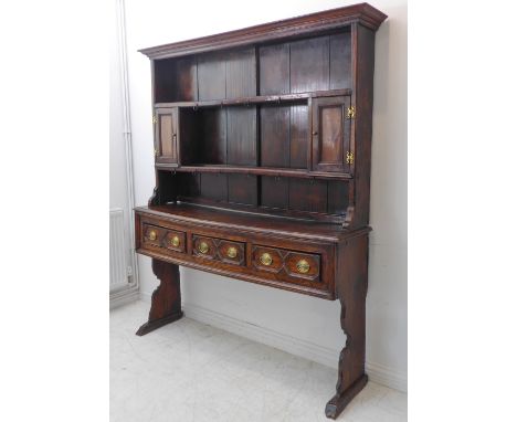 An unusual early 18th century antique elm Somerset Sedgemoor dresser: the flaring cornice above shelves and two panelled door