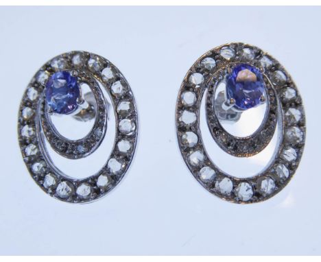 A pair of oval openwork white gold tanzanite and diamond cluster earrings