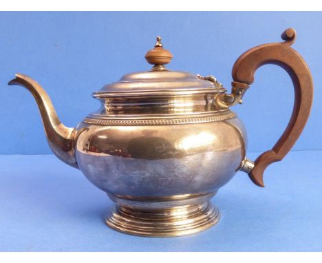 A hallmarked silver teapot with carved wooden handle and turned finial, maker's mark SD Ld, assayed London 1922 (total weight