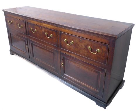 A circa 1770 oak dresser base, the moulded top above three frieze drawers retaining original brass swan-neck handles and furt