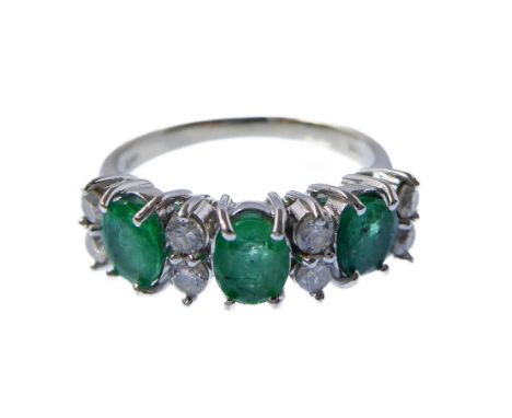 An emerald and diamond-set ring set with three oval mixed-cut emeralds and separated by four pairs of brilliant-cut diamonds,