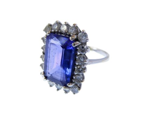 An tanzanite and diamond-set rectangular cluster ring, the step cut-cornered tanzanite within a surround of 18 brilliant-cut 
