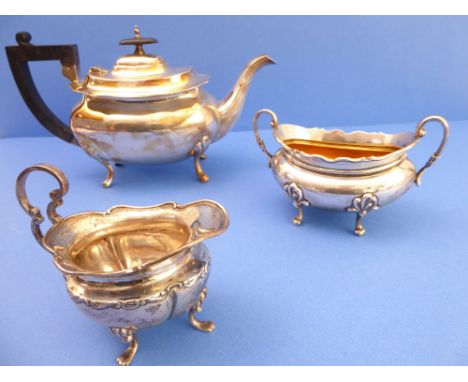 A three-piece hallmarked silver composite tea service: silver teapot by Walker &amp; Hall, assayed Sheffield 1918, a two-hand