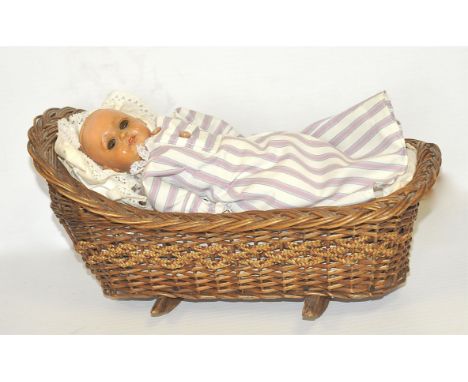 German Bisque Doll, dressed in pink and white striped dress, together with a wicker cradle, F-G (2)