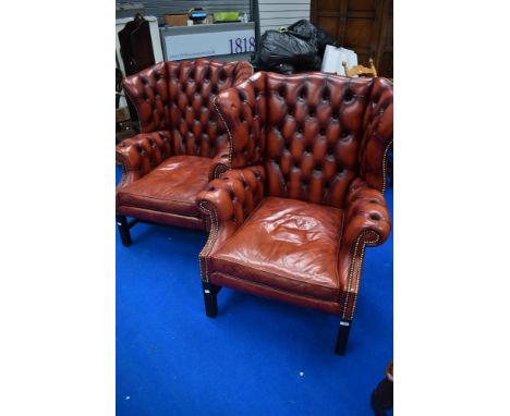 A pair of red leather button back wing armchairs, slight scratch to arms else good condition