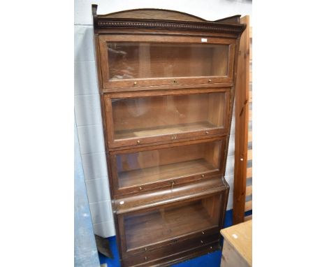 A 1920s 'The Lebus Bookcase' oak sectional/stacking bookcase with short three-quarter gallery over dentil carved frieze and f