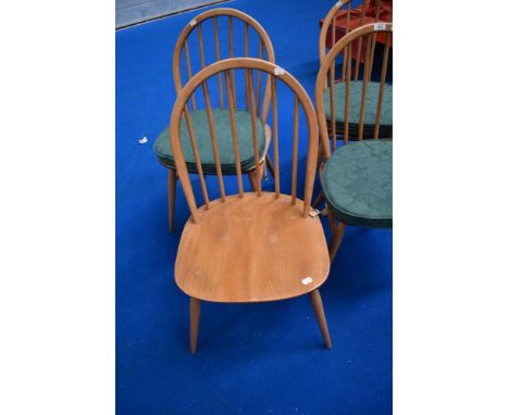 A set of four Ercol hoop and stick back chairs, with seat cushions and H stretchers, in light stain