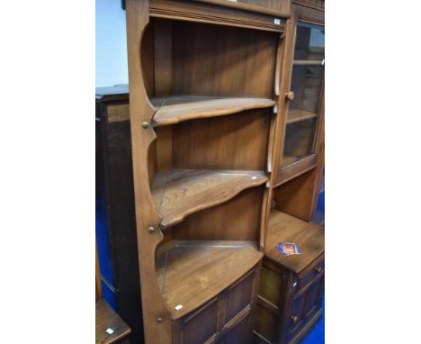 A modern Ercol mid corner shelf with cupboard under