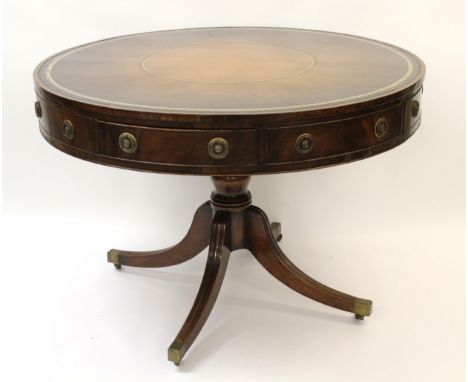 Late 19th / early 20th Century mahogany circular drum table having brown leather and gilt tooled inset top, above four opposi