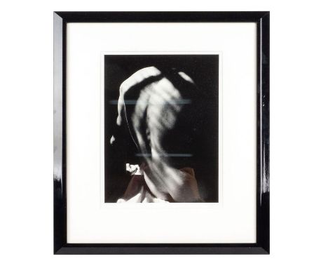 Intimate black and white portrait depicting a seated nude man turned away from the camera. Portrait is characterized by deep 