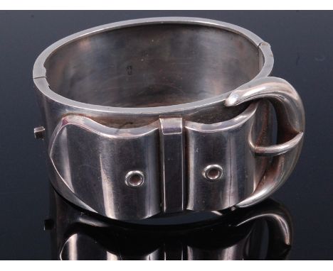 A silver hinged bangle in the form of a belt   Condition Report / Extra Information  Several small dents to the outside. 