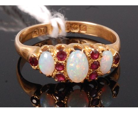 An 18ct gold, opal and ruby set dress ring, the three cabochon cut and claw set opals dispersed by small cut rubies, size R 