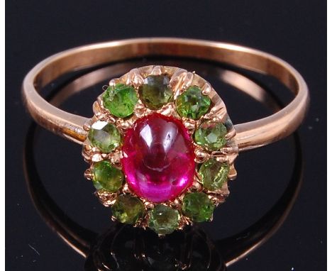 A ladies Russian 14ct gold dress ring, the central cabochon set ruby surrounded by ten peridot, size O, gross weight 2.1g