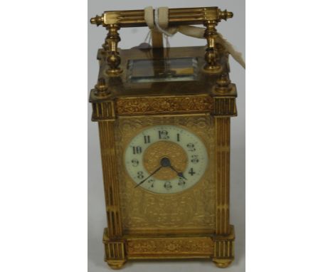 An early 20th century lacquered brass cased carriage clock, having circular enamelled dial with Arabic numerals, within flora
