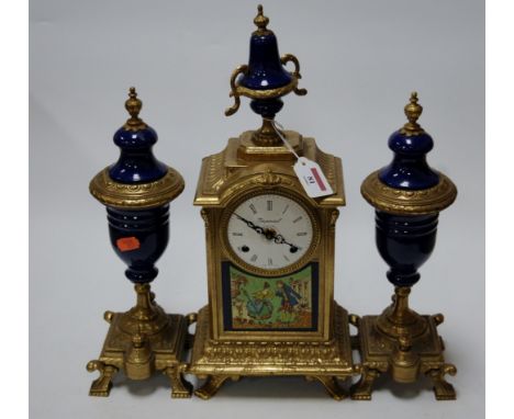 A reproduction French style gilt brass and porcelain clock garniture, the central clock having enamel dial with Roman numeral