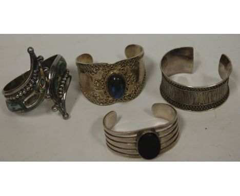 A ladies Mexican silver and abalone shell set hinged bangle, together with three other continental silver bangles (4)