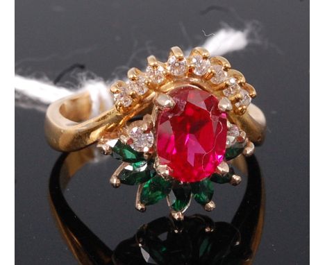 An 18ct gold dress ring, set with a large oval cut four claw set ruby, within a paste set surround, size O/P 