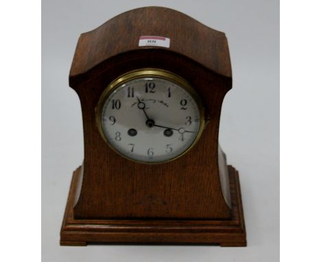 An Edwardian oak and boxwood strung mantel clock having an enamel dial with Arabic numerals, eight day movement striking on a