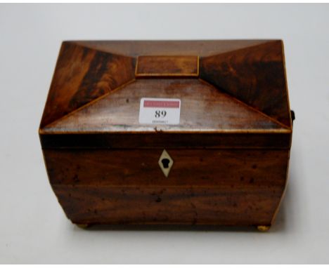 A Regency mahogany and boxwood strung tea caddy of sarcophagus form having brass ring handles and brass ball feet, width 20cm
