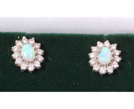 A pair of 18ct white gold, cabochon opal and diamond set flower head ear studs, 11mm