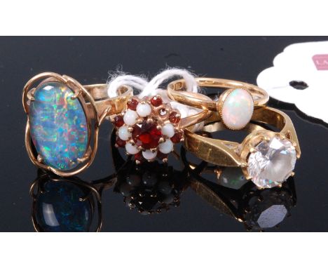 A 9ct gold opal set dress ring; together with a 9ct gold, garnet and opal set ring (one opal missing); one other opal ring; a