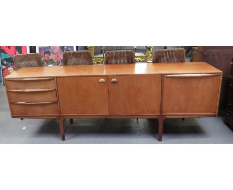 A McIntosh &amp; Co teak sideboard having central doors enclosing shaped shelf, flanked by three drawers and drop down panel,