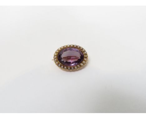 A Victorian amethyst and seed pearl oval brooch, stamped '15ct', 2.4 cm long, 5.3 g gross