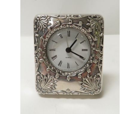 A quartz bedside alarm clock with a silver front, Italian marks and '925', embossed in the Edwardian style, 9cm high