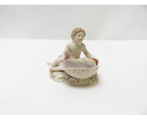 A Meissen ceramic salt cellar, in the form a boy holding a shell