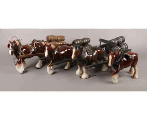 Four ceramic shire horses; three pulling barrel carts.  