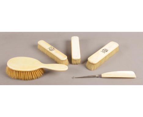 Four Ivory bedroom brushes, two of which are monogrammed, together with an ivory shoe horn and steel button hook.  