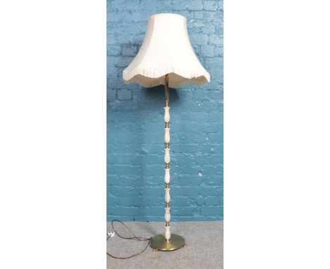 A brass and onyx standard lamp with frilled cream shade. In working order.  
