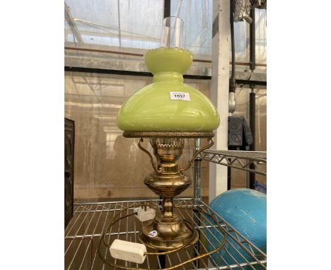 A BRASS TABLE LAMP CONVERTED FROM AN OIL LAMP WITH A GREEN GLASS SHADE