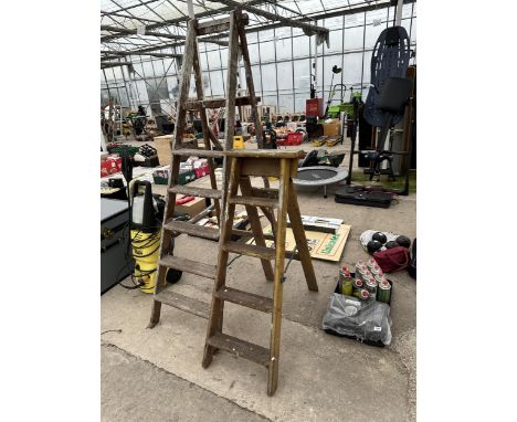 A VINTAGE FOUR RUNG WOODEN STEP LADDER AND A FIVE RUNG WOODEN STEP LADDER