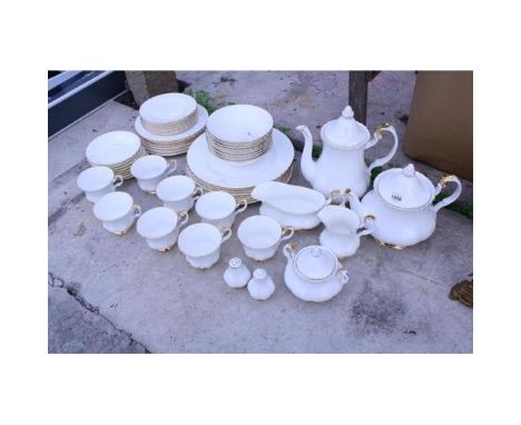 A ROYAL ALBERT VAL D'OR DINNER SERVICE COMPRISING OF TRIOS, PLATES, TEAPOT, COFFEE POT, MILK JUG AND SUGAR BOWL ETC