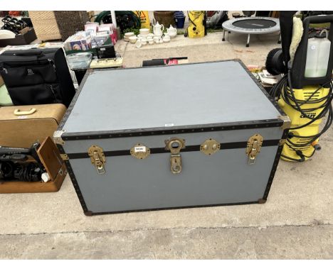 A LARGE BLUE TRUNK WITH BRASS FITMENTS