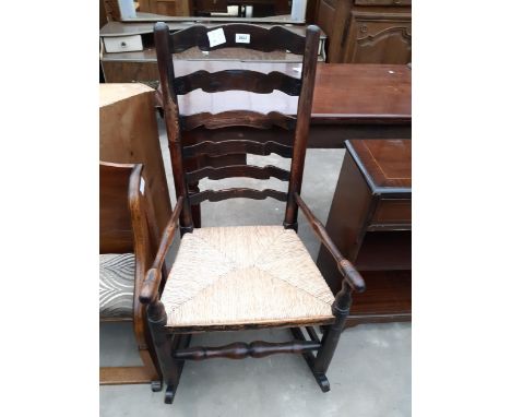 A 19TH CENTURY ELM LADDER BACK ROCKING CHAIR WITH RUSH SEAT