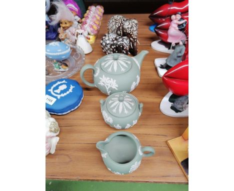 THREE PIECES OF GREEN WEDGWOOD JASPERWARE TO INCLUDE A TEAPOT, SUGAR BOWL AND CREAM JUG PLUS TWO WOODEN ELEPHANTS