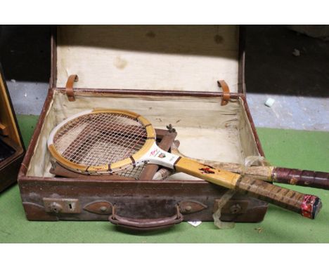 A VINTAGE SUITCASE CONTAINING TWO OLD WOODEN TENNIS RACKETS