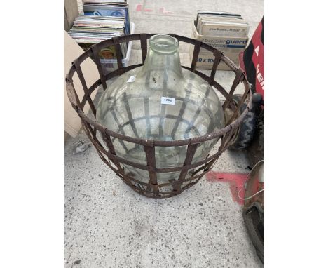 A LARGE VINTAGE GLASS CARBOUY WITH WIRE CAGE