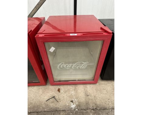 A RED COUNTERTOP COCA-COLA BOTTLE FRIDGE