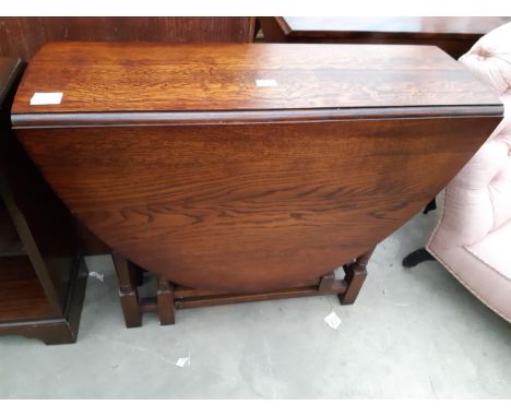 AN OVAL OAK GATE LEG TABLE ON TURNED LEGS, 53" X 36" OPENED