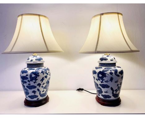 TABLE LAMPS, pair, 60cm high, 40cm diameter, Chinese export style blue and white ceramic with dragon decoration with shades, 