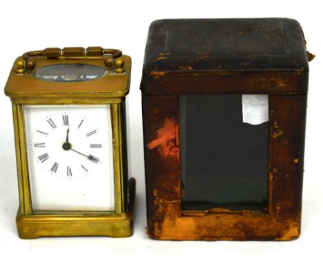A late 19th century brass carriage clock, rectangular white enamel dial set with Roman numerals, in leather and glass case, h