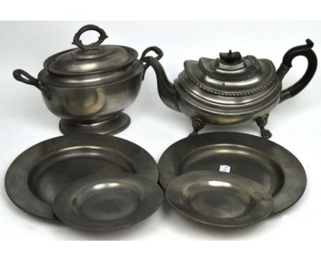 A small quantity of pewter to include a teapot, four plates, an oval tureen and a lamp.